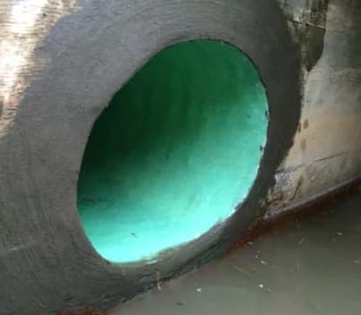 Restored interior of a lined drain pipe after CIPP installation at an industrial site.